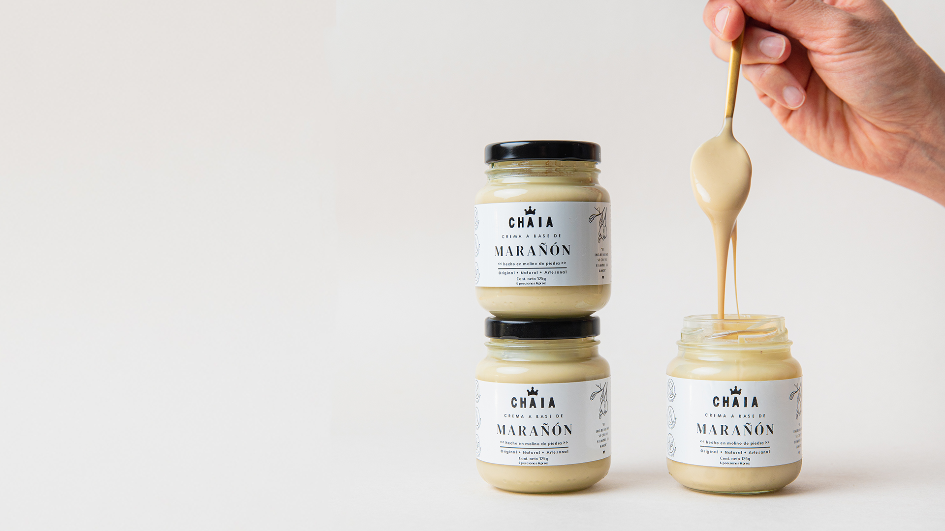 tres envases de crema o mantequilla de marañon esparcible Chaia en envase de 125g con una cuchara saliendo del envase mostrando su textura sedosa